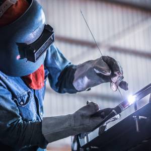 Factory welder worker during gas metal arc welding works