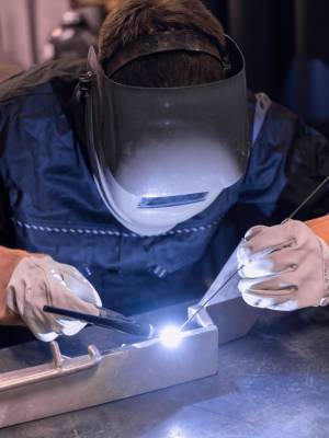 The welder is welding a structural steel with gas metal welding (MIG i MAG ) in the workshop.