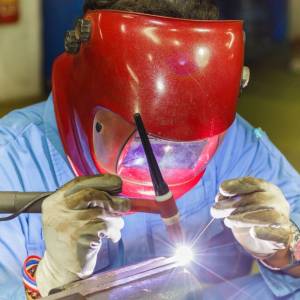 Industrial welder welding fabricated construction in factory, MIG and MAG Welding process, FCAW